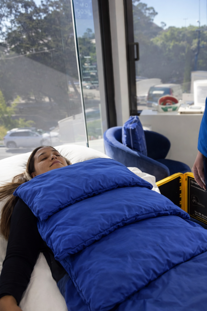 PEMF therapy at LifeRx Wellness in Willis, Texas, showing a client resting comfortably with high-intensity blue PEMF mats supporting cellular recovery and relaxation