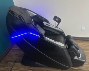 Medical-grade black zero-gravity massage chair with glowing blue accents, used for deep-tissue muscle recovery at LifeRx Wellness in Willis, TX.